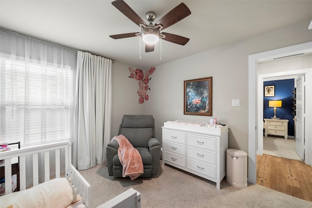 bedroom with multiple windows, light colored carpet, and ceiling fan