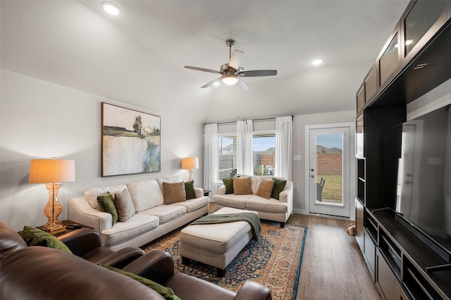 living room featuring dark wood-type flooring, ceiling fan, and lofted ceiling