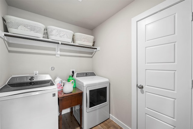 clothes washing area featuring washer and clothes dryer and wood-type flooring