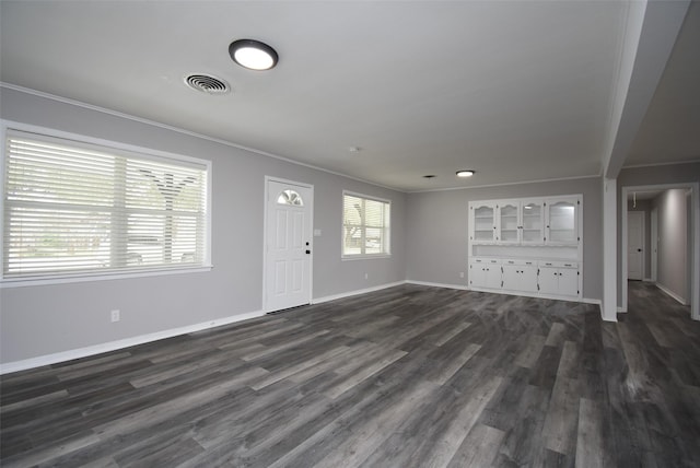 unfurnished living room featuring dark hardwood / wood-style flooring and crown molding