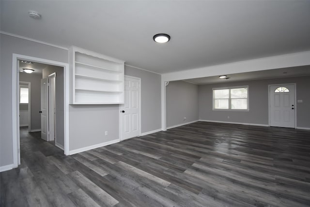 unfurnished living room with ornamental molding and dark hardwood / wood-style floors