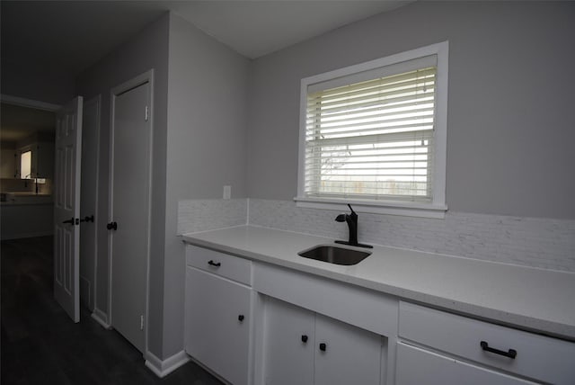 kitchen with white cabinetry, sink, and backsplash