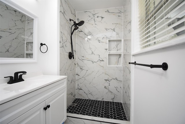 bathroom with tiled shower and vanity