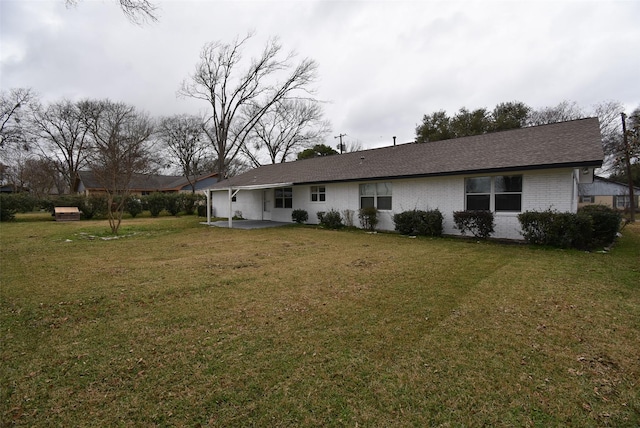 rear view of property featuring a lawn and a patio