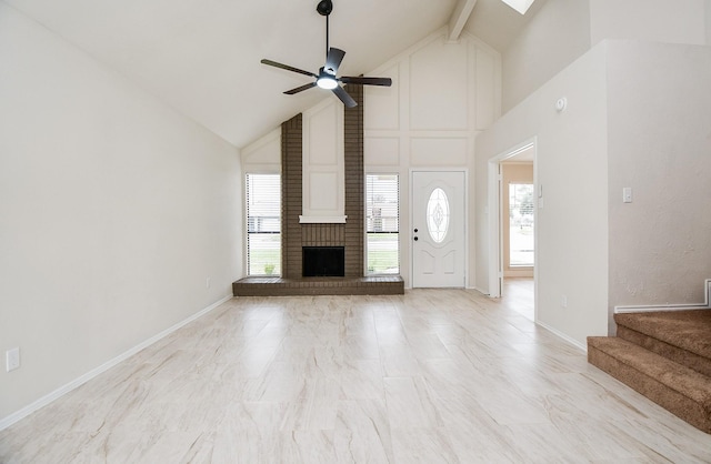 unfurnished living room with beamed ceiling, ceiling fan, a fireplace, and high vaulted ceiling