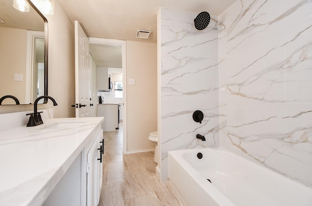 full bathroom with vanity, toilet, and tiled shower / bath combo