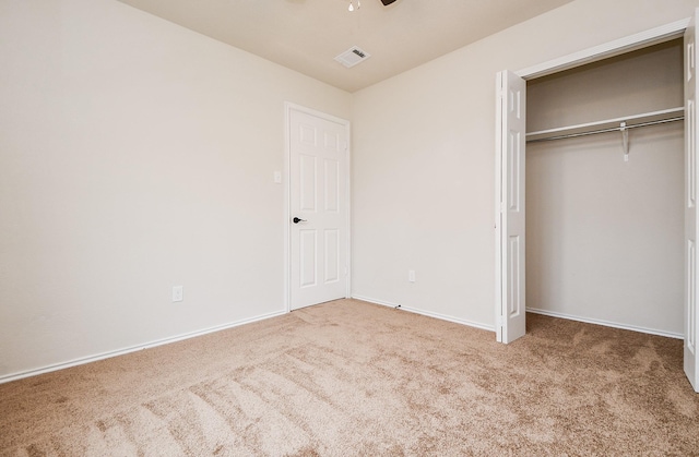 unfurnished bedroom with light colored carpet, a closet, and ceiling fan