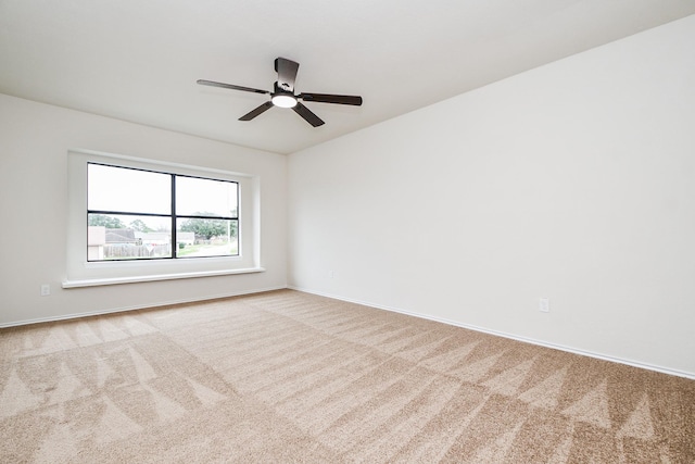 spare room with light colored carpet and ceiling fan