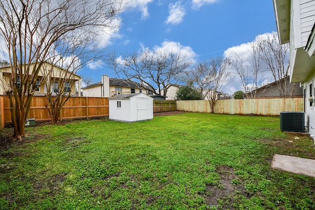 view of yard featuring a storage shed and central AC unit