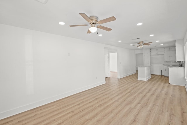 unfurnished living room featuring ceiling fan and light hardwood / wood-style floors