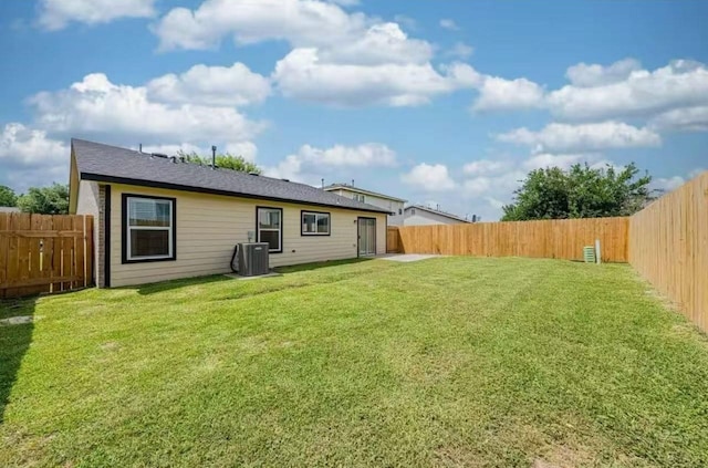 rear view of house featuring a yard and central AC