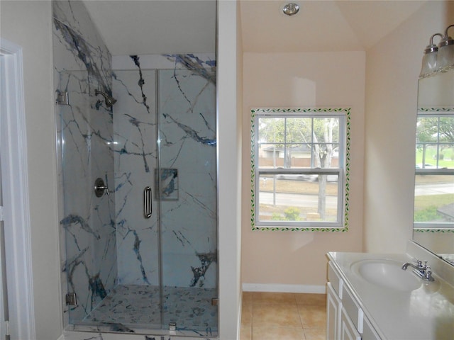 bathroom featuring vanity, tile patterned flooring, a wealth of natural light, and walk in shower