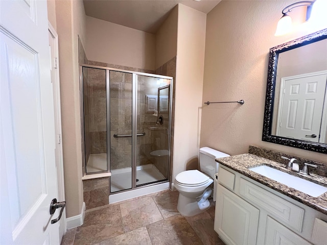 bathroom featuring vanity, toilet, and a shower with shower door