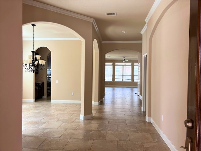 corridor with an inviting chandelier and crown molding