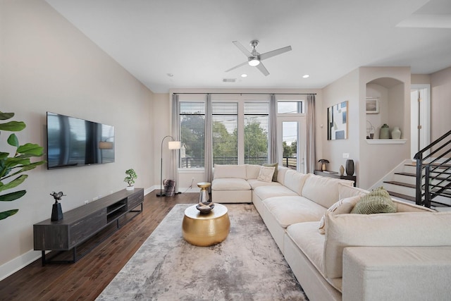 living room featuring ceiling fan and dark hardwood / wood-style flooring