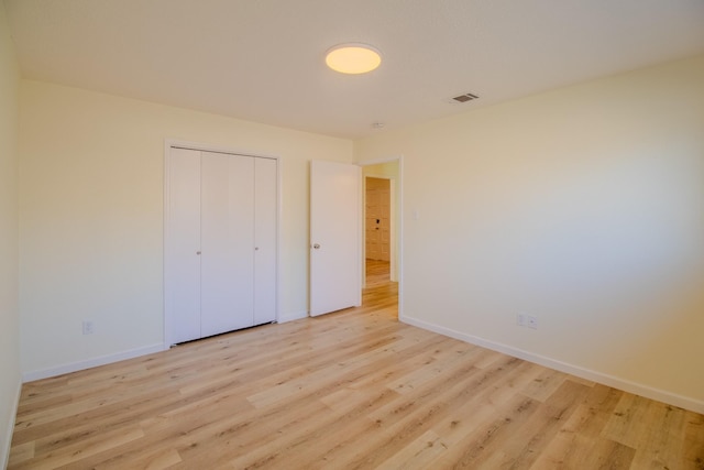 unfurnished bedroom with light hardwood / wood-style floors and a closet