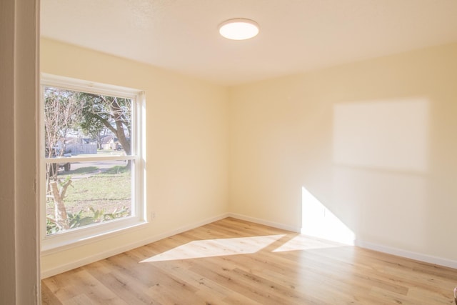 spare room featuring light hardwood / wood-style flooring and plenty of natural light