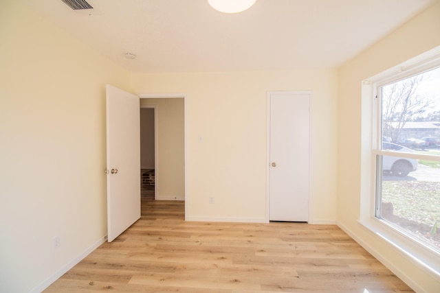 unfurnished bedroom featuring light hardwood / wood-style floors and multiple windows