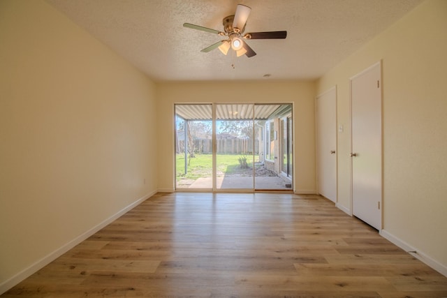 empty room with ceiling fan, a textured ceiling, and light wood-type flooring