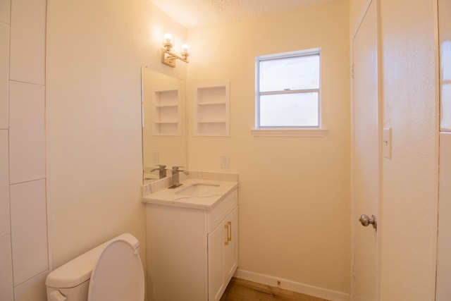 bathroom featuring vanity, a textured ceiling, and toilet