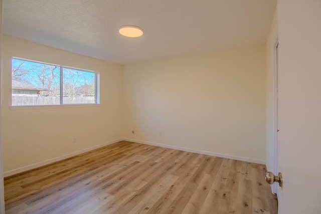 unfurnished room with light hardwood / wood-style floors and a textured ceiling