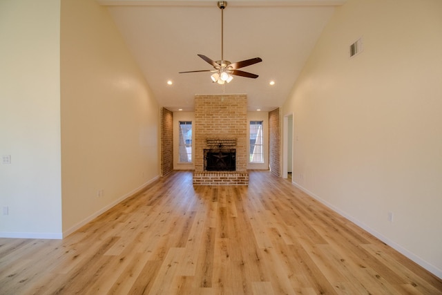 unfurnished living room with ceiling fan, a fireplace, high vaulted ceiling, and light hardwood / wood-style flooring