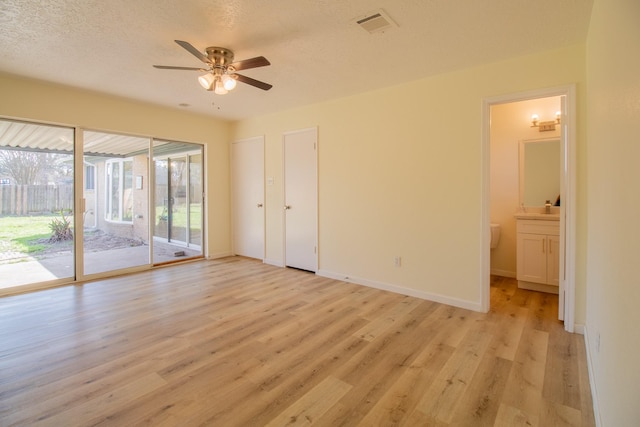 spare room featuring ceiling fan, light hardwood / wood-style floors, and a textured ceiling