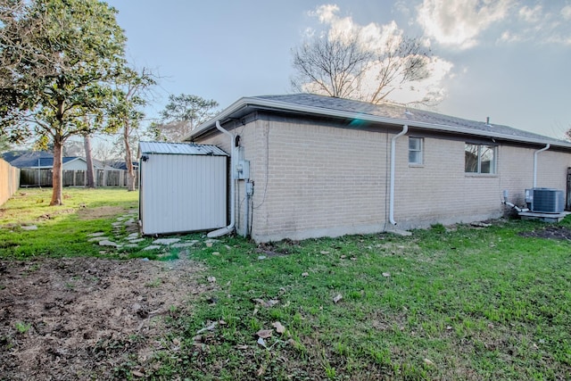 view of property exterior featuring a storage shed, central AC unit, and a lawn