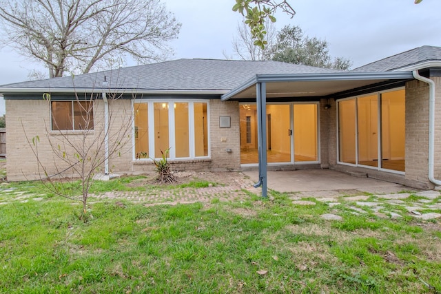 back of property featuring a lawn and a patio