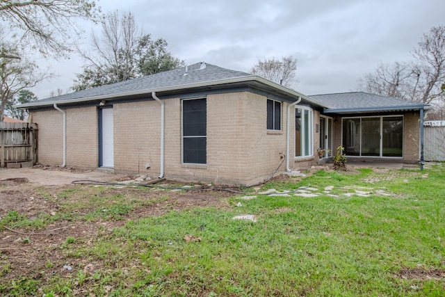 rear view of house with a lawn and a patio