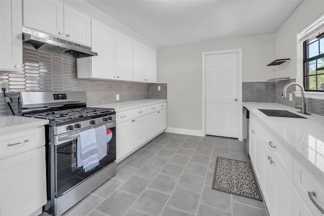 kitchen with light stone counters, appliances with stainless steel finishes, sink, and white cabinets