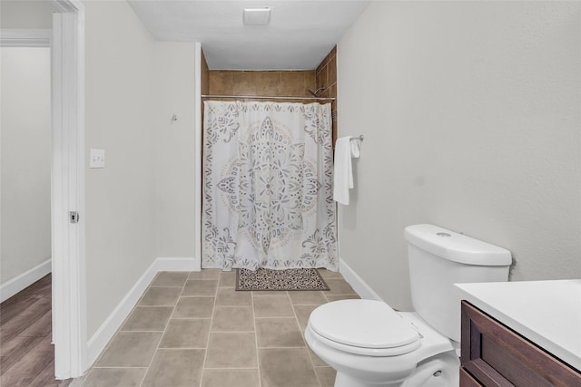 bathroom with a shower with curtain, vanity, tile patterned floors, and toilet