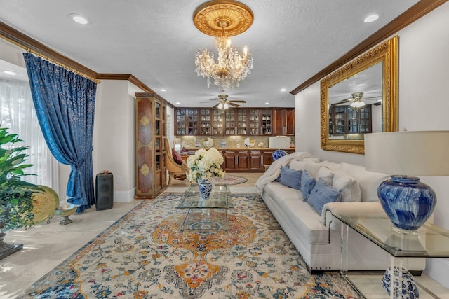 living room featuring ceiling fan with notable chandelier, ornamental molding, and a textured ceiling