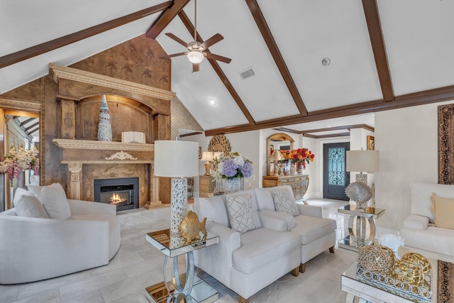 living room with beam ceiling, high vaulted ceiling, a premium fireplace, and ceiling fan