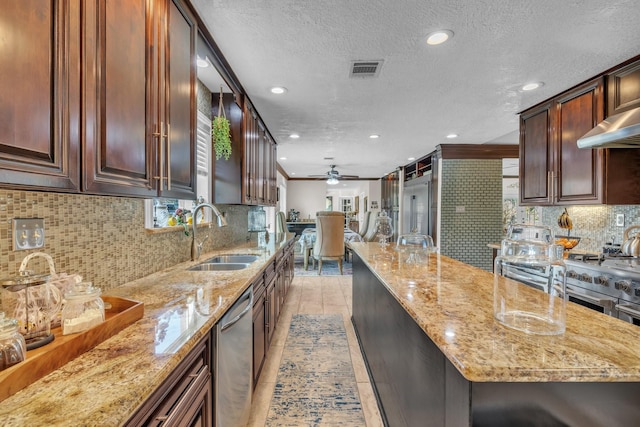 kitchen featuring light stone counters, stainless steel dishwasher, ceiling fan, and sink