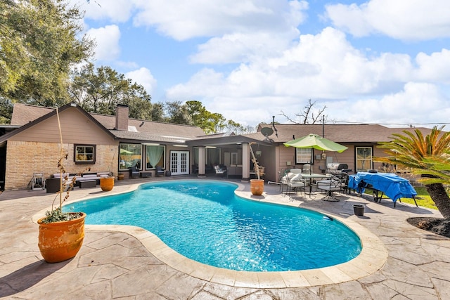 view of swimming pool with a patio and french doors