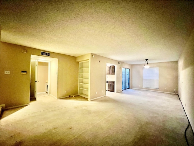 unfurnished living room featuring carpet flooring and a textured ceiling