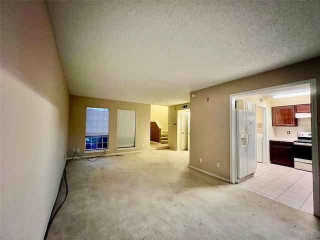 unfurnished living room with light carpet and a textured ceiling