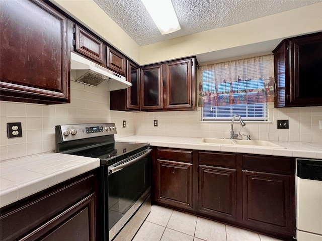 kitchen with tile countertops, tasteful backsplash, dishwasher, sink, and electric range