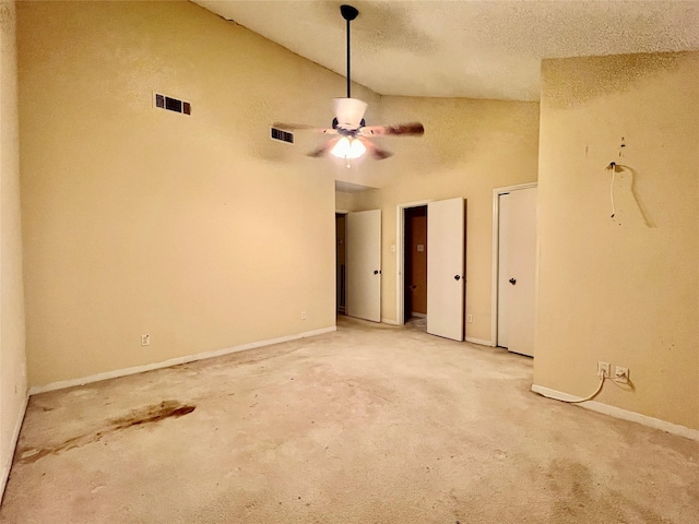 unfurnished room featuring lofted ceiling, light colored carpet, a textured ceiling, and ceiling fan