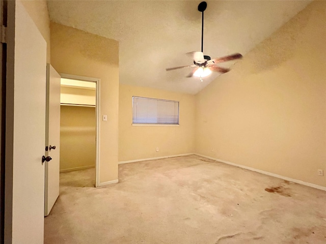 unfurnished bedroom featuring ceiling fan, light colored carpet, and lofted ceiling