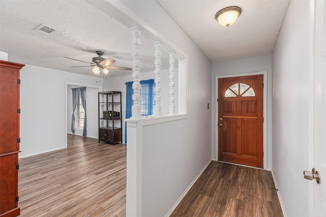 entryway with ceiling fan, wood-type flooring, and a textured ceiling