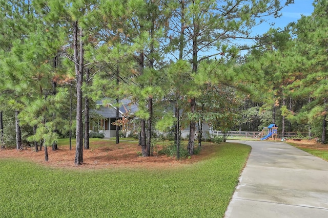 view of home's community with a playground and a lawn