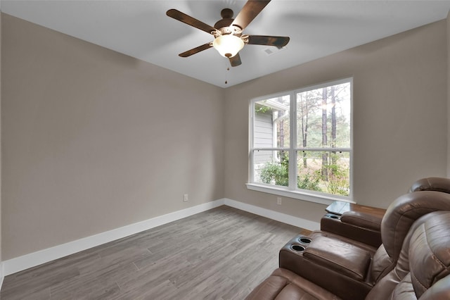 living area featuring hardwood / wood-style flooring and ceiling fan