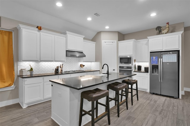 kitchen featuring white cabinetry, a breakfast bar, and appliances with stainless steel finishes