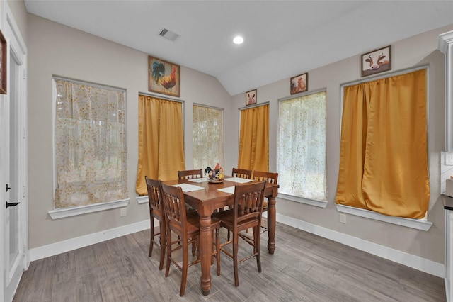 dining area with lofted ceiling and hardwood / wood-style floors