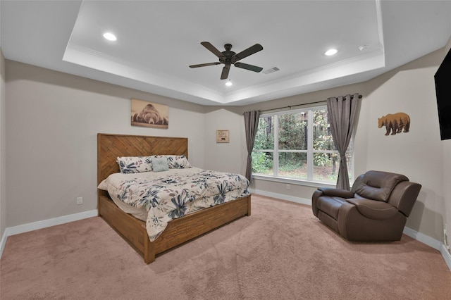 carpeted bedroom featuring a raised ceiling, ornamental molding, and ceiling fan