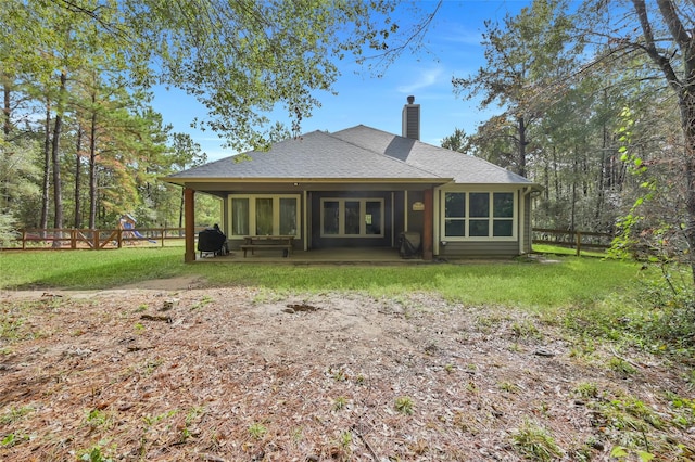 rear view of property featuring a lawn and a patio