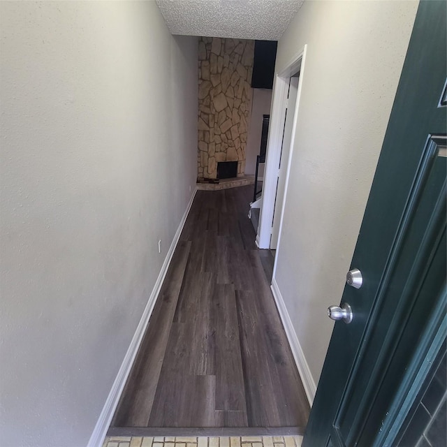 hall with dark hardwood / wood-style floors and a textured ceiling