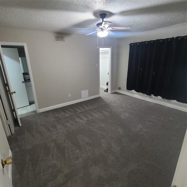 unfurnished bedroom with ceiling fan, a textured ceiling, and dark carpet